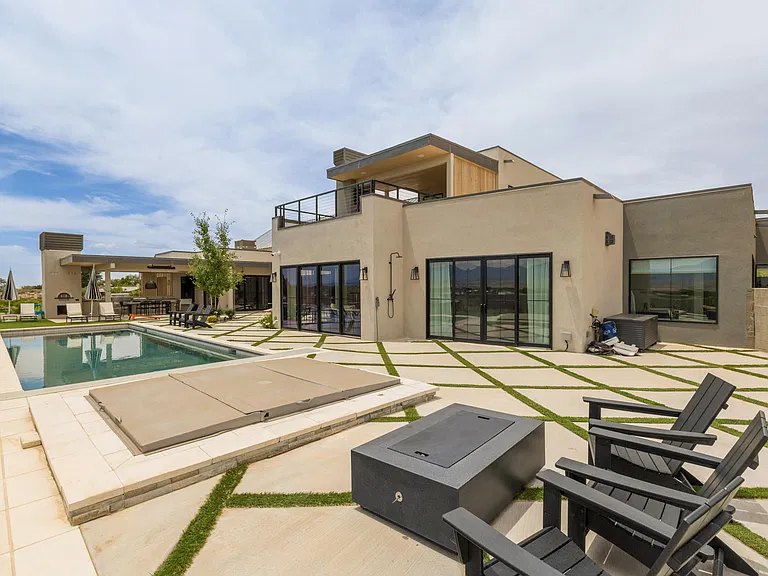 Paver and turf courtyard with fire table, spa, and pool at a Corrales, NM custom home by Infinity Builders