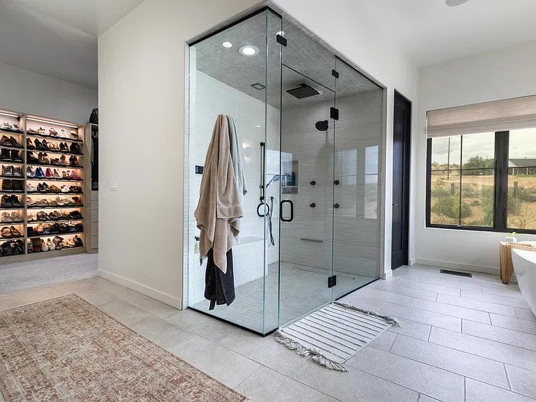Frameless glass steam shower with matte black fixtures in a Corrales, NM primary suite by Infinity Builders