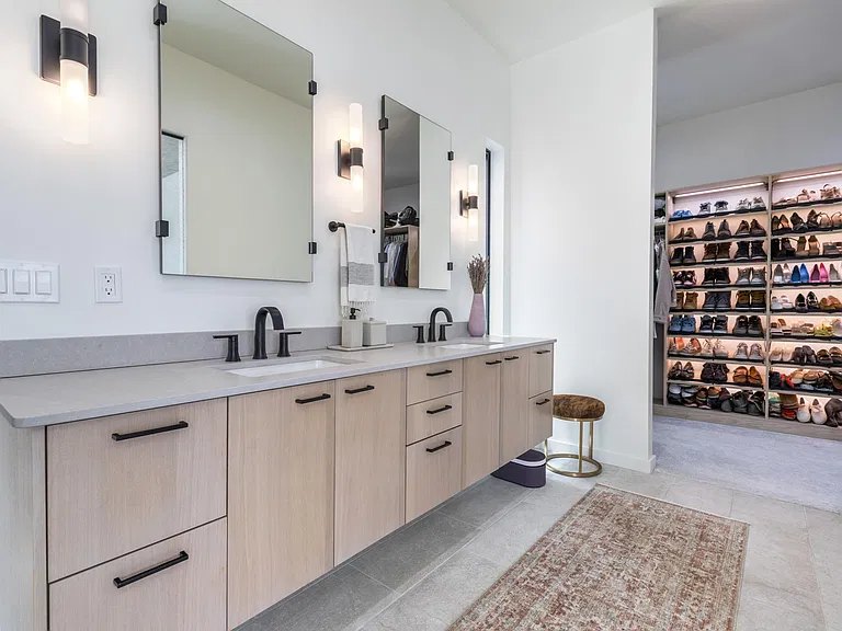 Floating double vanity with backlit mirrors and walk-in closet in a Corrales, NM custom home by Infinity Builders