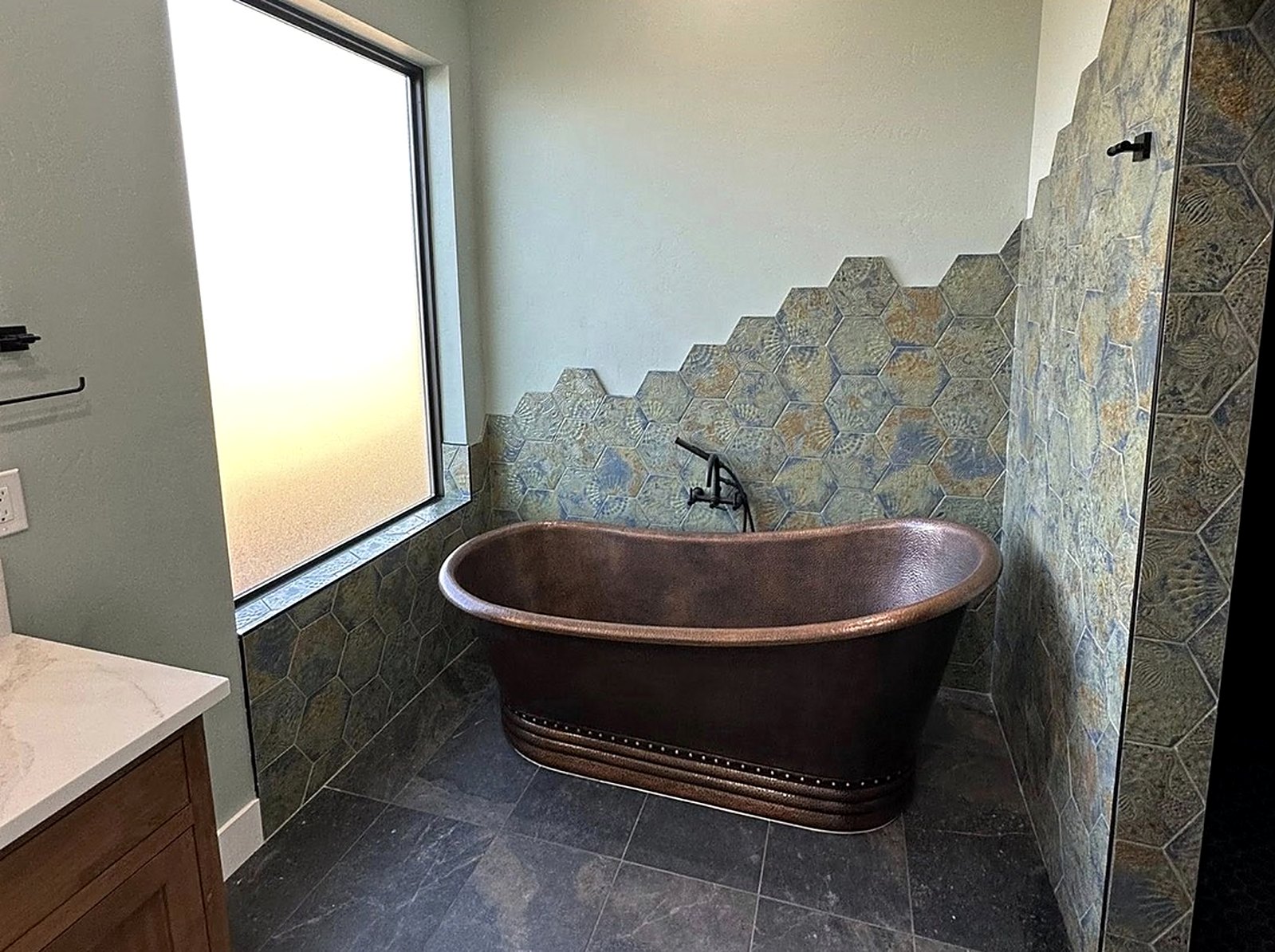 Copper soaking tub on slate tile