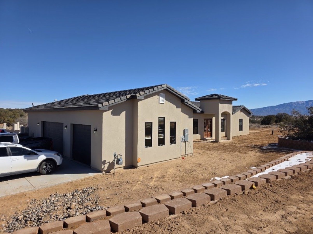 Tile-roof custom home with Sandia Mountains behind