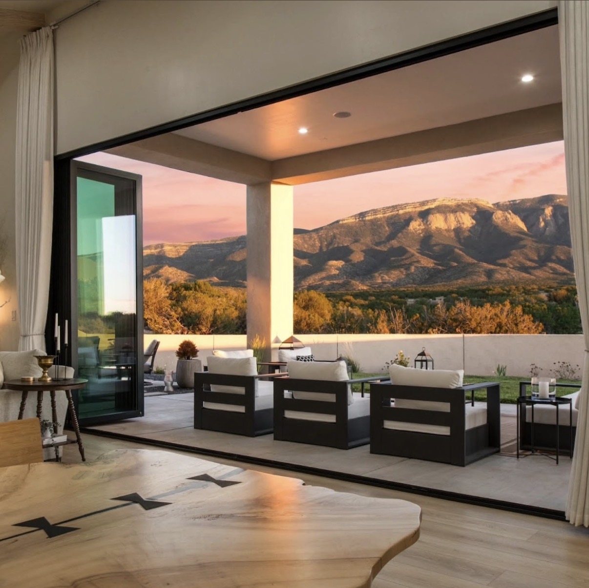 Contemporary patio and living room with a sunset view of the Sandia Mountains